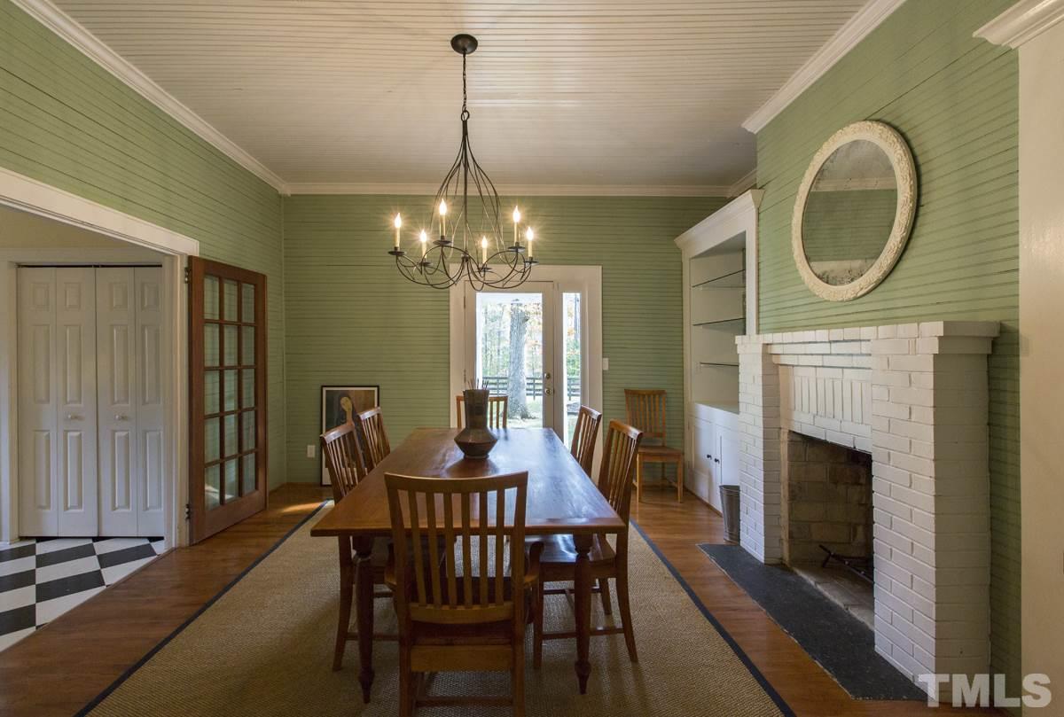 2730 Little River Church Road Hurdle Mills, NC 27541 - Photo 19 of 25 a dining room with furniture a fireplace and a chandelier