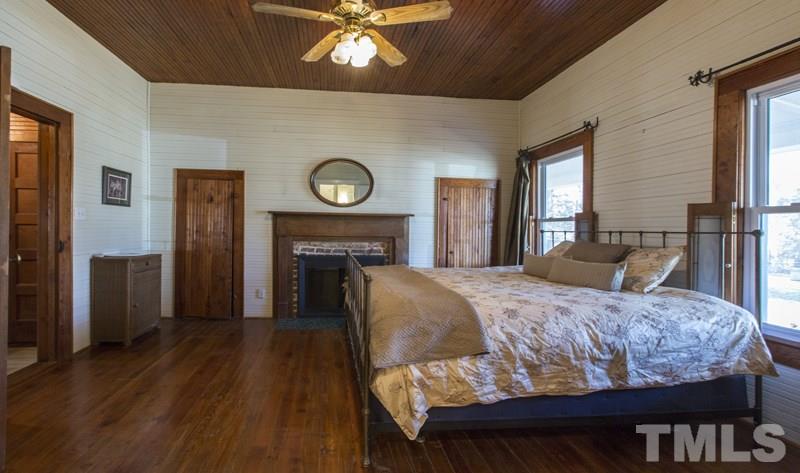 2730 Little River Church Road Hurdle Mills, NC 27541 - Photo 22 of 25 a bedroom with a bed and a chandelier