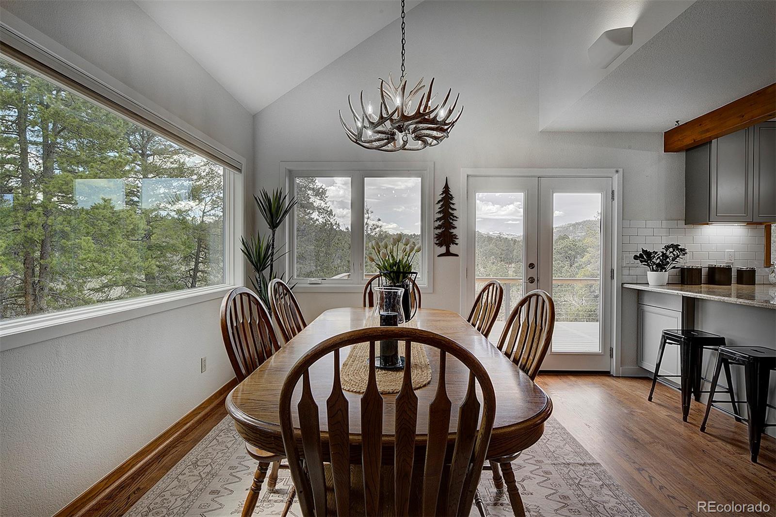 27987 Richmond Hill Road Conifer, CO 80433 - Photo 20 of 46 a view of a dining room with furniture window and wooden floor
