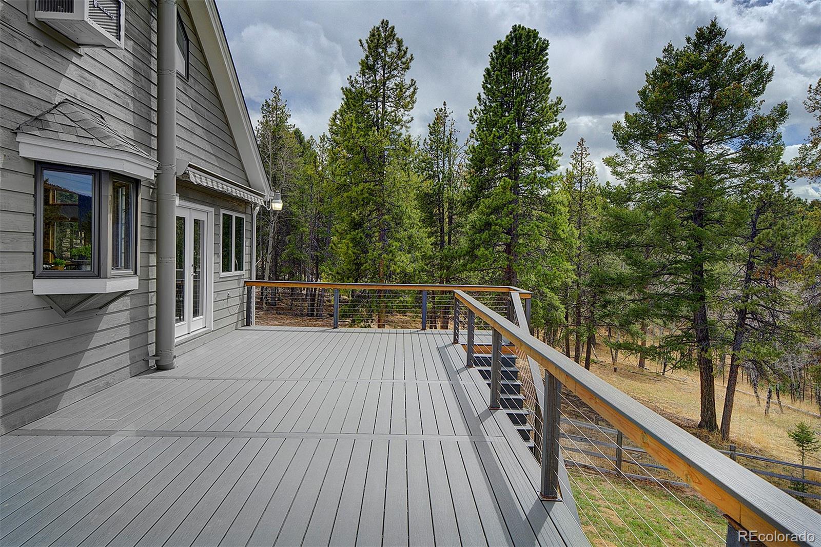 27987 Richmond Hill Road Conifer, CO 80433 - Photo 25 of 46 a balcony with wooden floor and fence