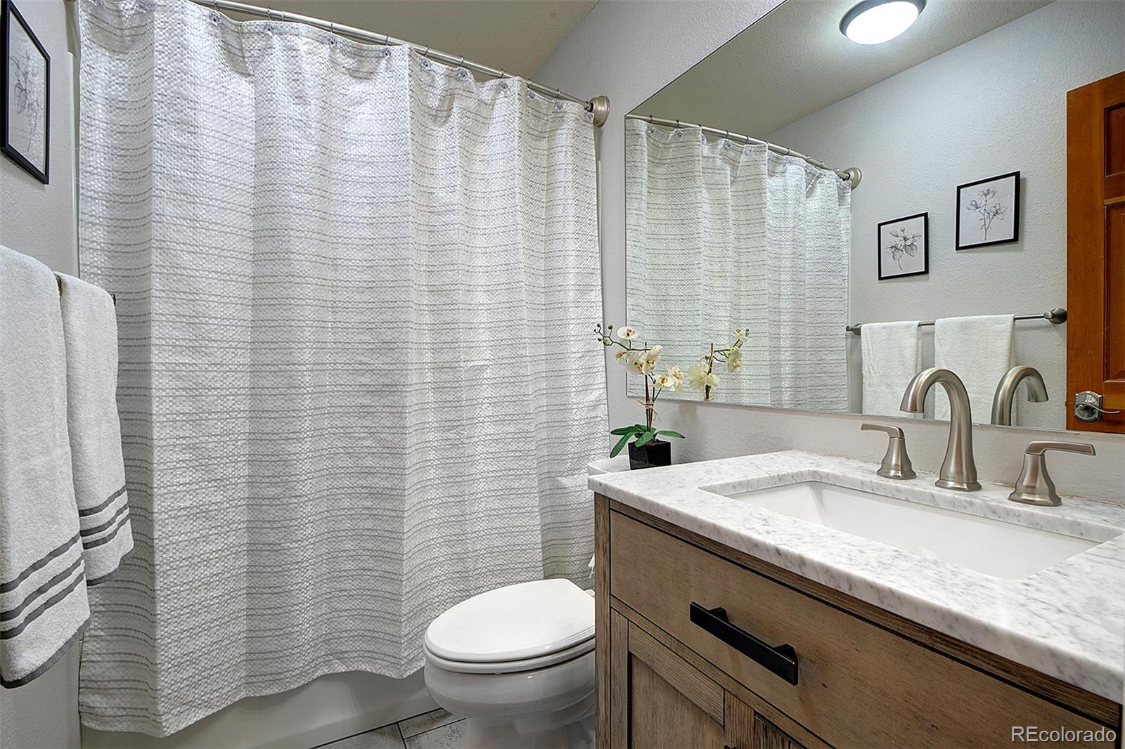 27987 Richmond Hill Road Conifer, CO 80433 - Photo 29 of 46 a bathroom with a granite countertop sink toilet and mirror