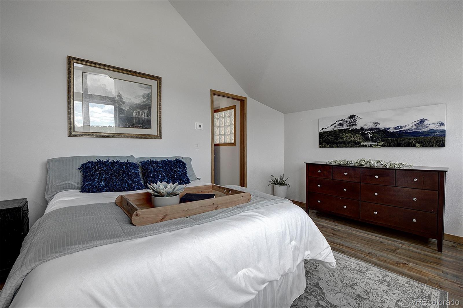 27987 Richmond Hill Road Conifer, CO 80433 - Photo 31 of 46 a bedroom with a bed and wooden floor