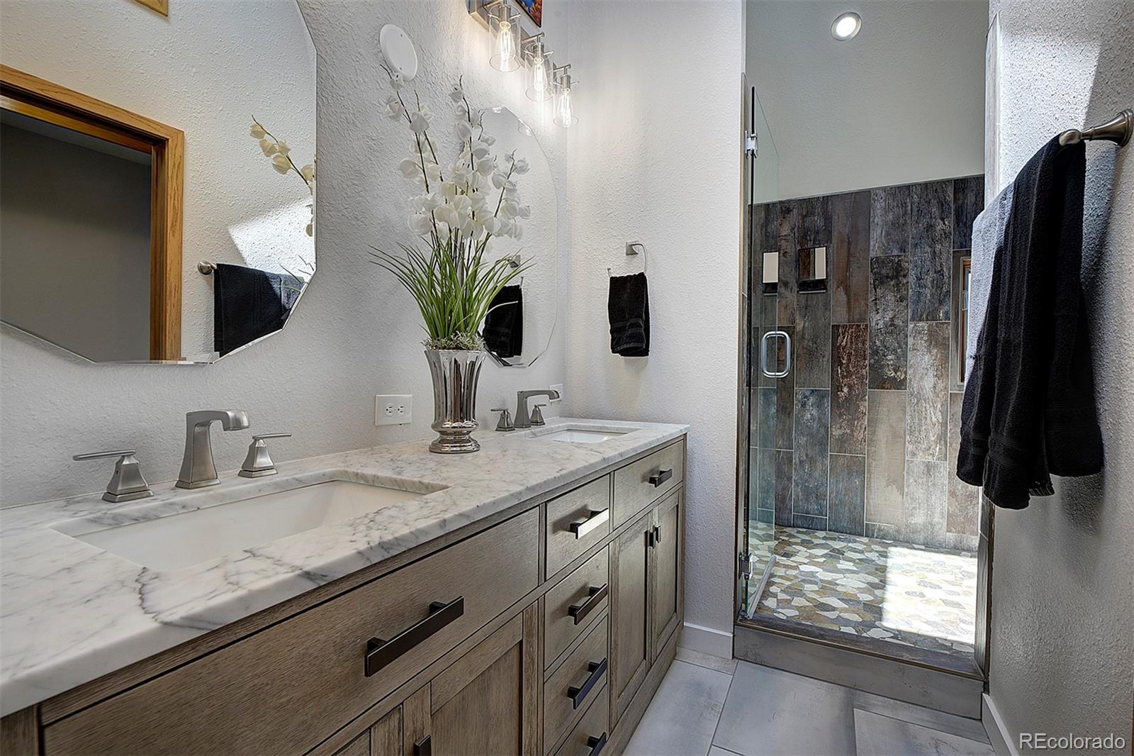 27987 Richmond Hill Road Conifer, CO 80433 - Photo 34 of 46 a bathroom with a granite countertop sink a shower and a mirror