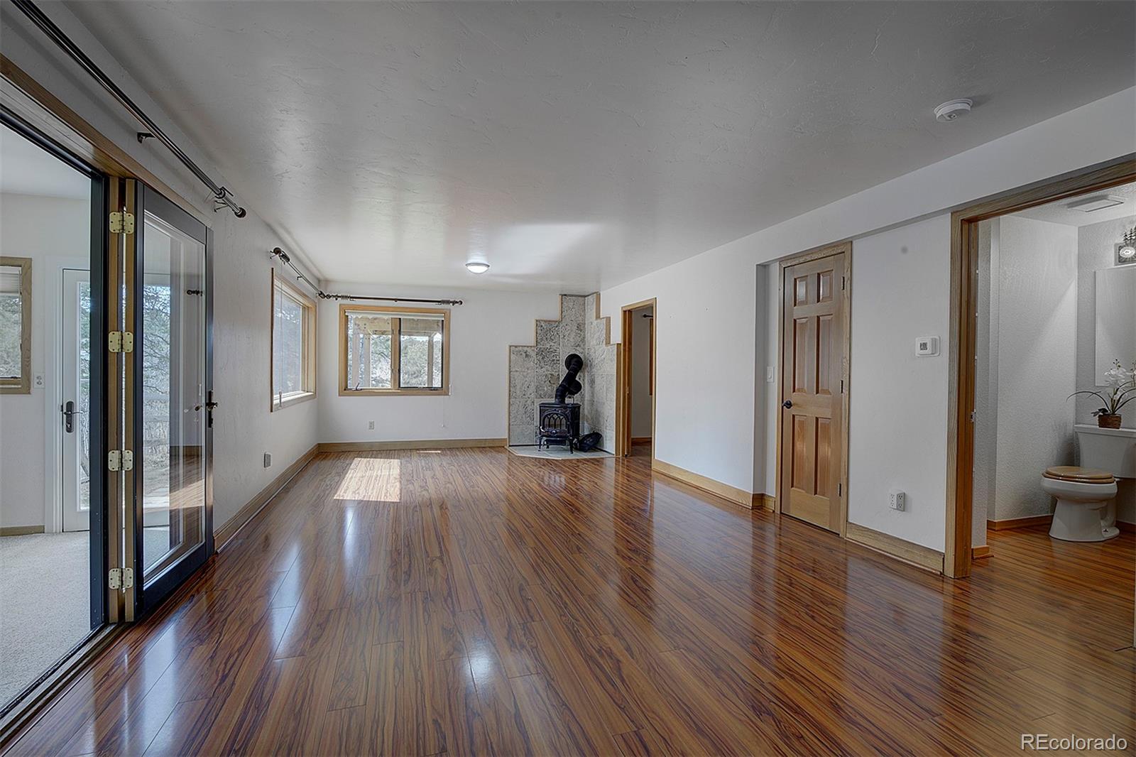 27987 Richmond Hill Road Conifer, CO 80433 - Photo 39 of 46 a view of a big room with wooden floor and a windows