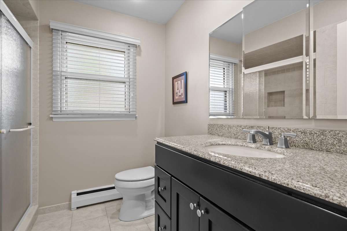 49 Larkdale E Road Deerfield, IL 60015 - Photo 11 of 24 a bathroom with a granite countertop sink a toilet and a window