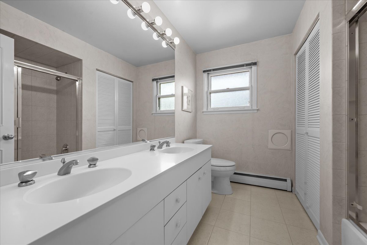 49 Larkdale E Road Deerfield, IL 60015 - Photo 15 of 24 a bathroom with a double vanity sink toilet and a mirror
