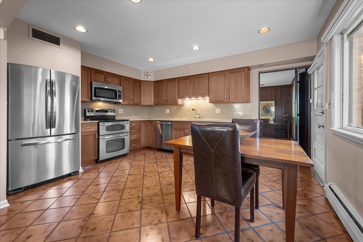 49 Larkdale E Road Deerfield, IL 60015 - Photo 3 of 24 a kitchen with stainless steel appliances granite countertop a table chairs sink refrigerator and microwave