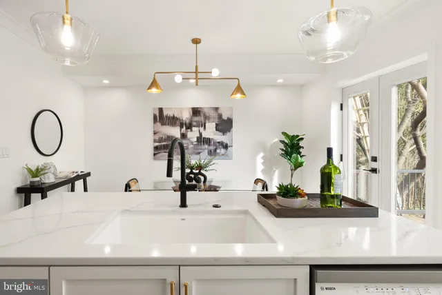 a kitchen with kitchen island stainless steel appliances a sink a stove and a wooden floors