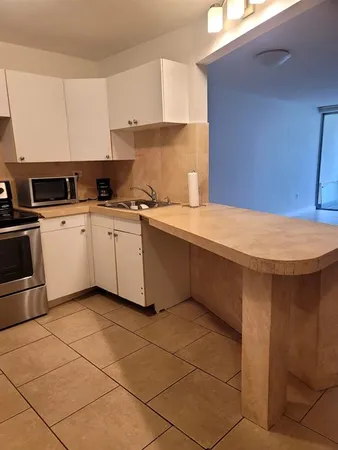 a kitchen with a cabinets a sink and a stove