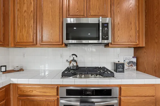 a kitchen with stove top oven and cabinets