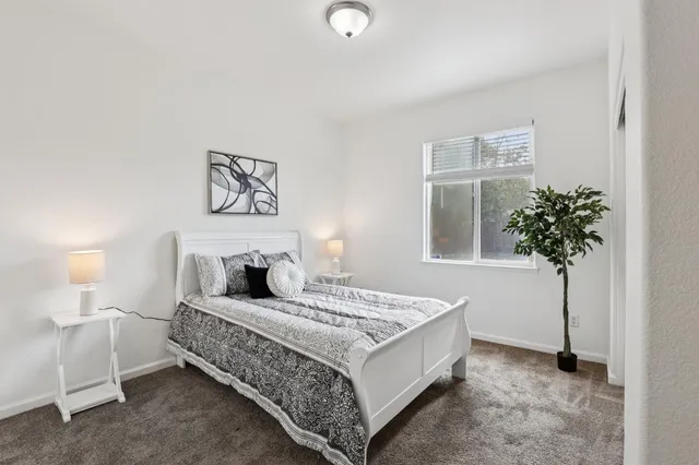 a bedroom with a bed and a potted plant