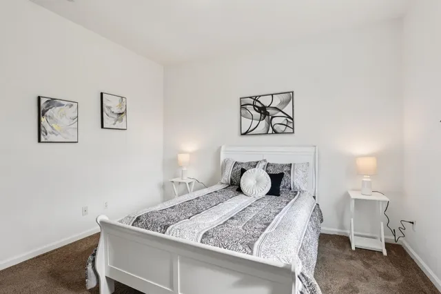 a bedroom with a bed and painting on the wall