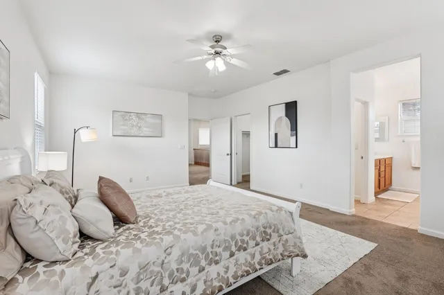 a bedroom with a large bed and a chandelier