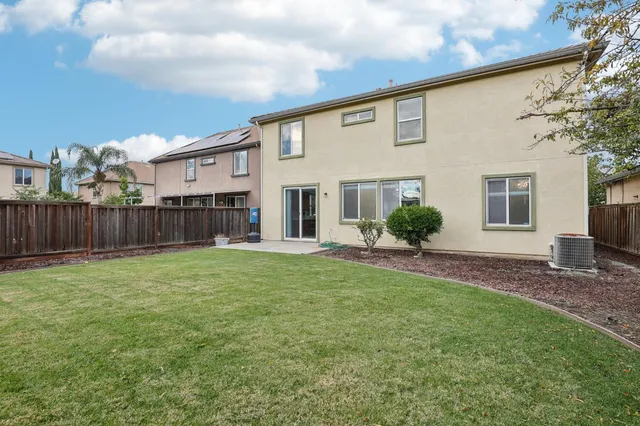 a view of a house with backyard and sitting area