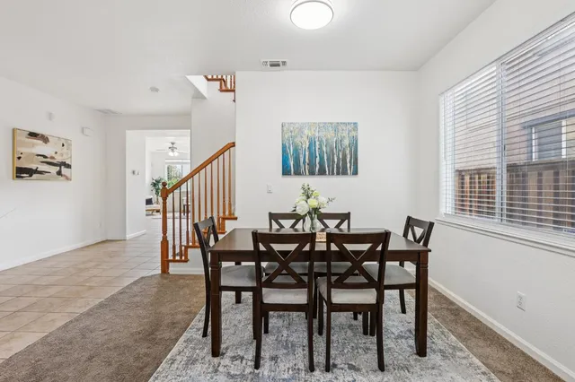a view of a dining room and livingroom with furniture wooden floor and a rug