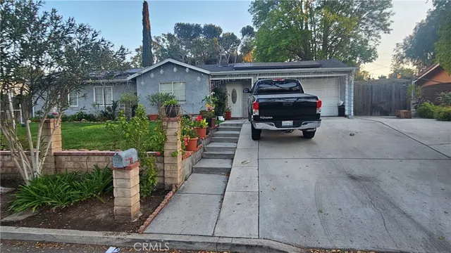 a front view of a house with a garden and trees