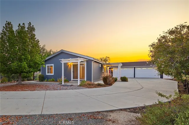a view of a house with a yard and large trees
