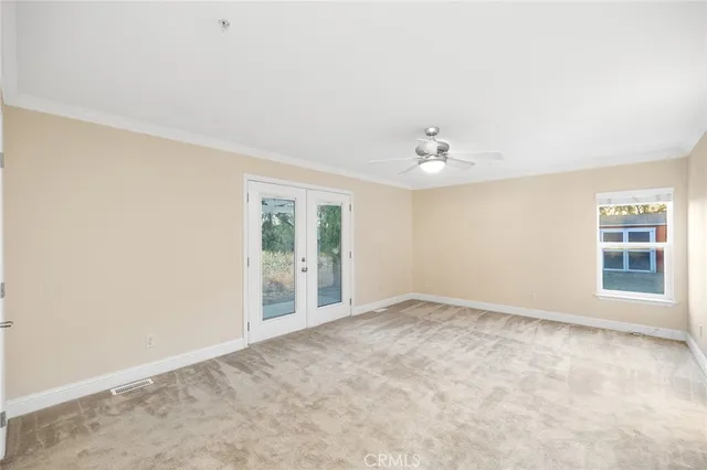 an empty room with a ceiling fan and a window
