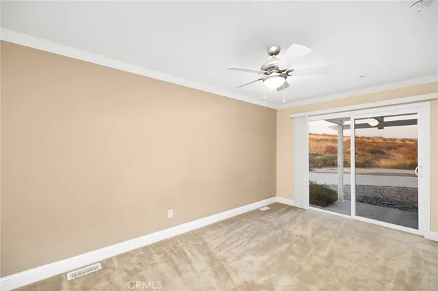 a view of a room with a ceiling fan and a window
