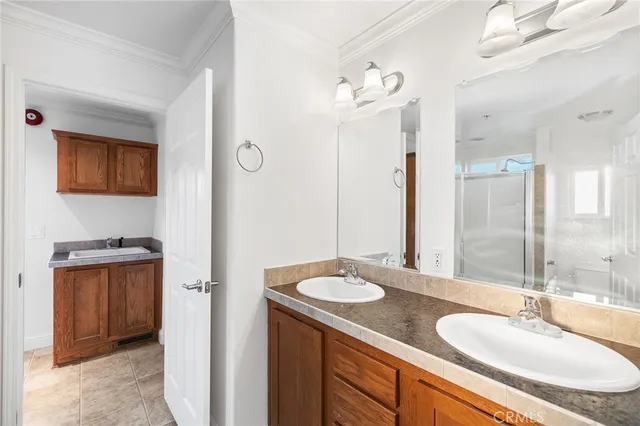 a bathroom with a sink double vanity granite tub shower and a mirror