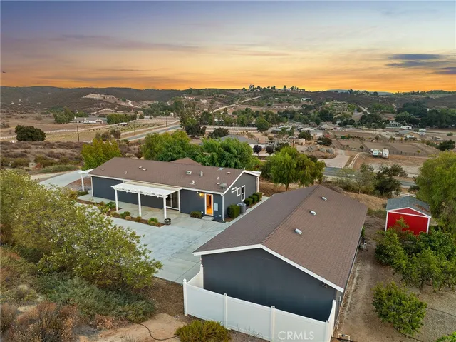 an aerial view of residential houses with outdoor space and ocean view