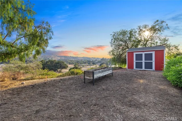 a backyard of a house with large trees and a tree