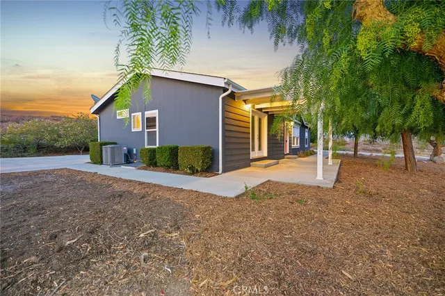 a view of a house with backyard and trees