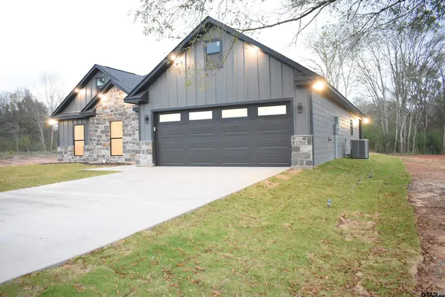 a front view of a house with a yard and trees