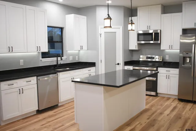 a kitchen with stainless steel appliances granite countertop a sink stove and refrigerator