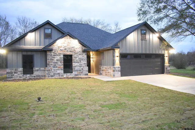 a front view of house with yard outdoor seating and garage