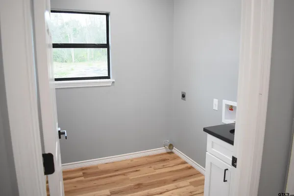 a kitchen with stainless steel appliances kitchen island granite countertop a refrigerator a stove and a sink with wooden floor
