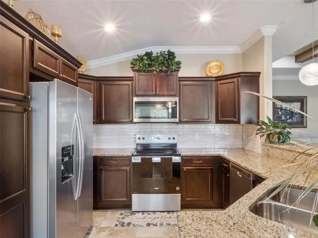 a kitchen with stainless steel appliances granite countertop a sink stove and refrigerator