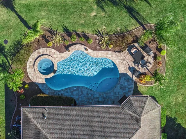 an aerial view of a house with garden space and swimming pool