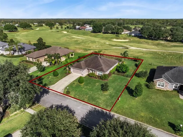 an aerial view of a houses with a yard and lake view