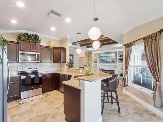 a kitchen with stainless steel appliances kitchen island granite countertop a sink and a stove