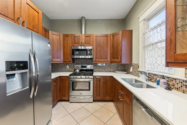 a kitchen with stainless steel appliances a sink cabinets and a refrigerator