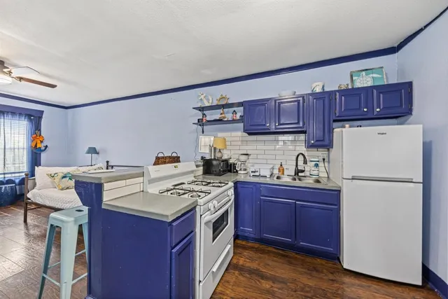 a kitchen with a stove a refrigerator and a wooden cabinets