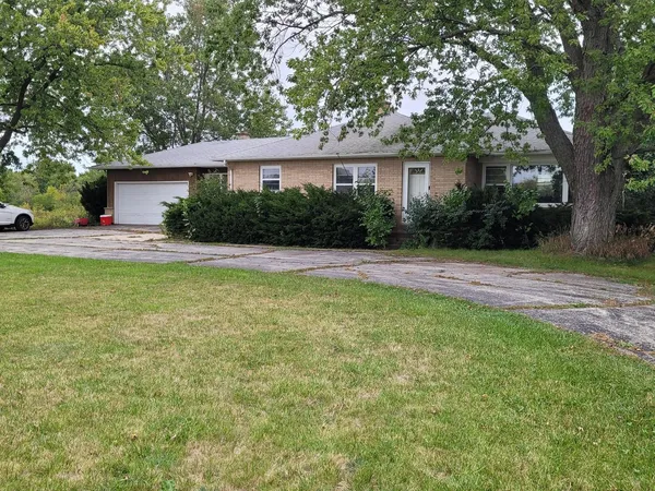 a view of a house with a yard and a large tree