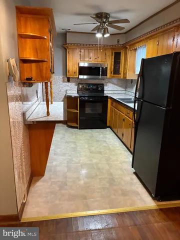 a kitchen with stainless steel appliances granite countertop wooden cabinets a stove a sink and a refrigerator