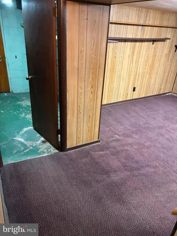 a view of an empty room with wooden floor and windows