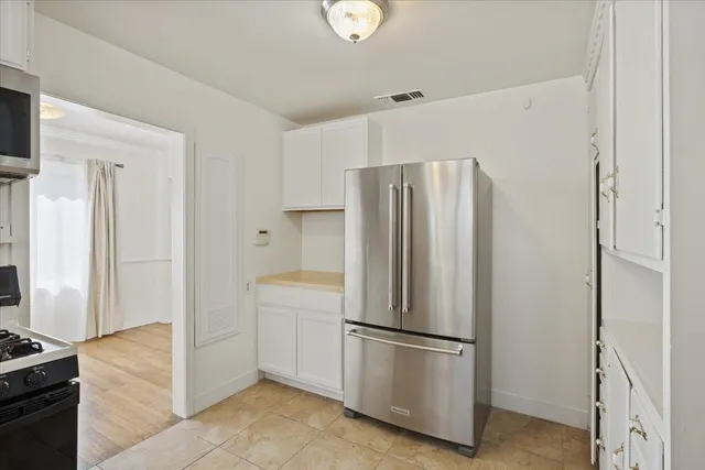 a white refrigerator freezer and a stove sitting inside of a kitchen