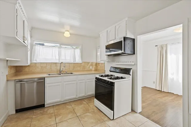 a kitchen with a stove top oven sink and cabinets
