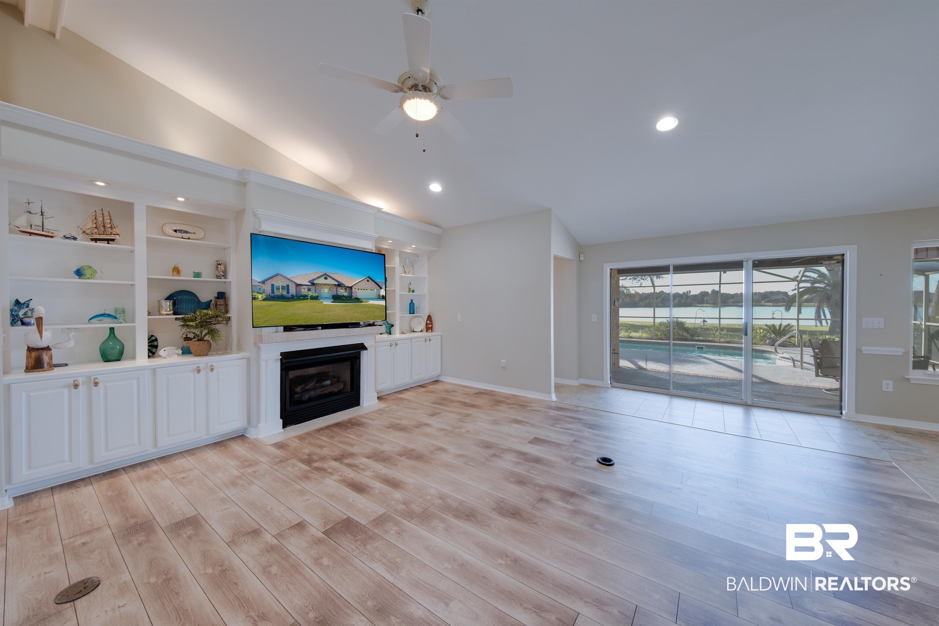 9462 Lakeview Drive Foley, AL 36535 - Photo 9 of 50 Unfurnished living room featuring vaulted ceiling, built in shelves, light hardwood / wood-style floors, and ceiling fan