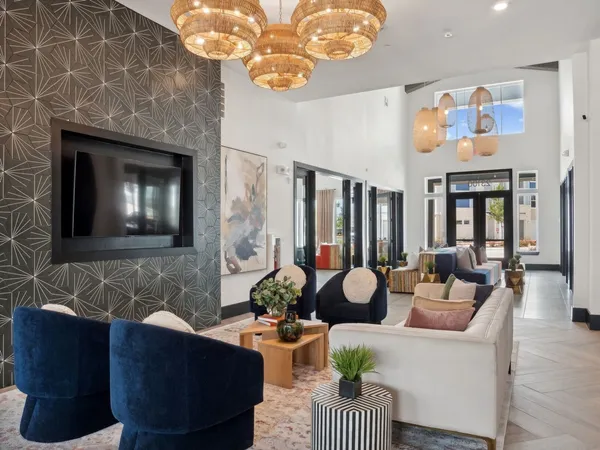 a living room with furniture a fireplace and a chandelier