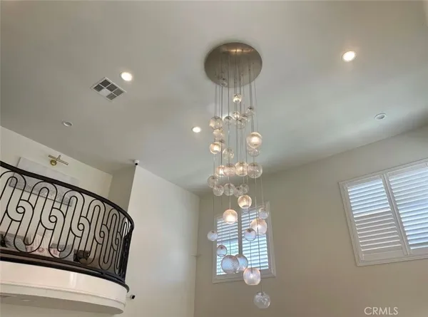 a bedroom with a large bed chandelier and a window
