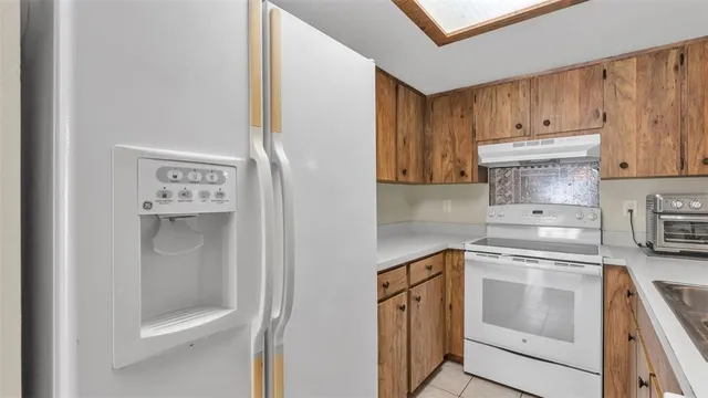 a kitchen with a refrigerator sink and cabinets