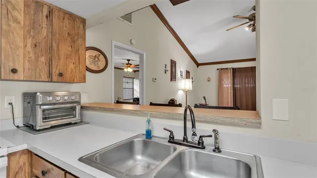 a kitchen with a sink and a stove with wooden floor