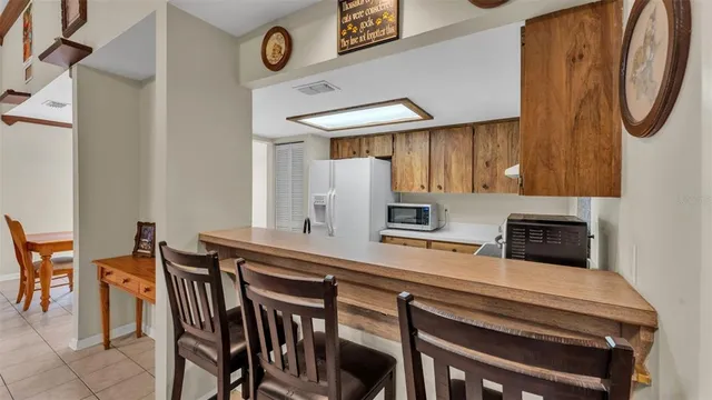 a kitchen with stainless steel appliances a table chairs and a refrigerator