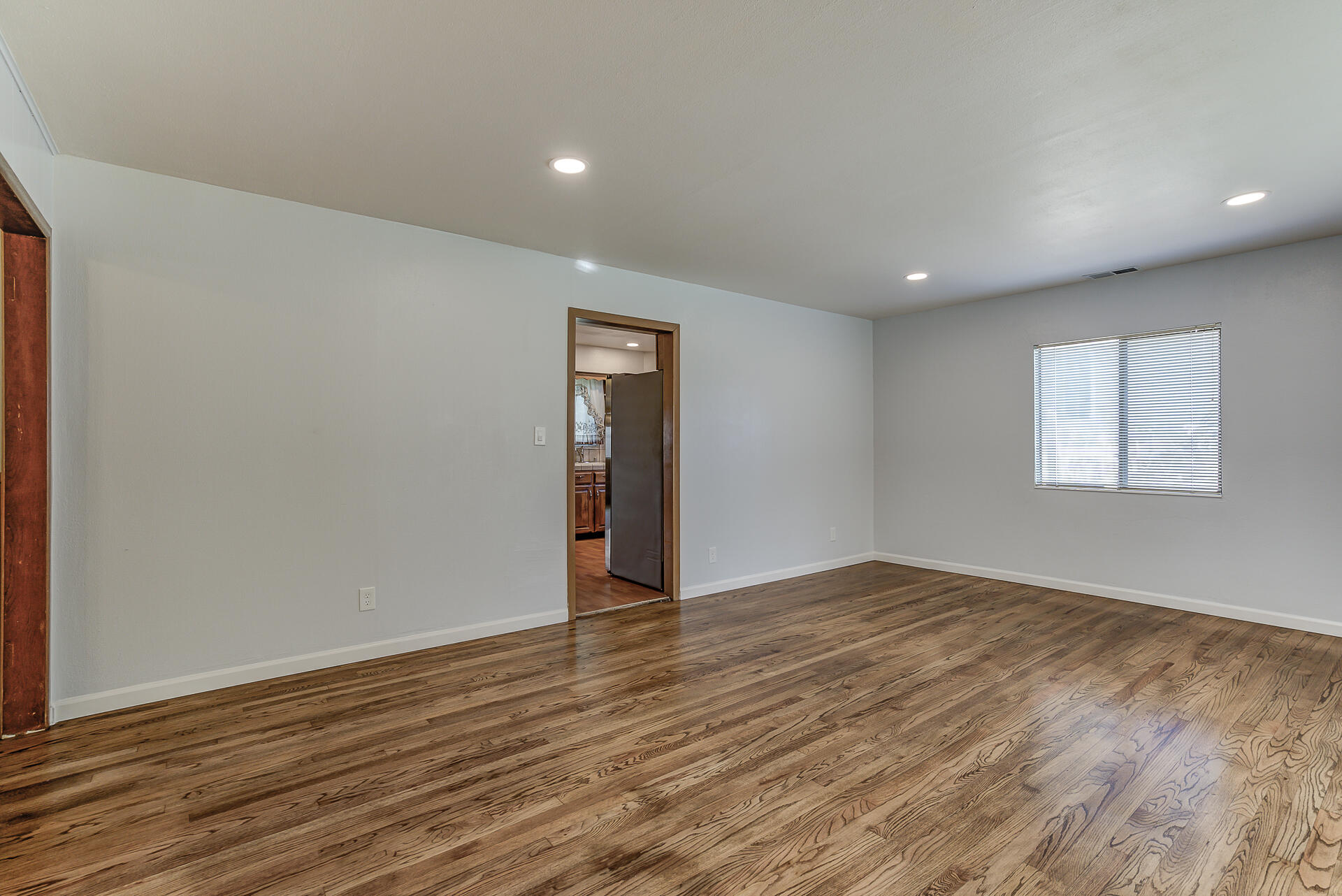 1445 Miller Way Red Bluff, CA 96080 - Photo 4 of 34 a view of an empty room with wooden floor and a window