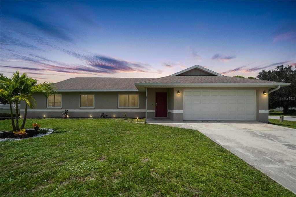 590 Ridgewood Street Northwest Port Charlotte, FL 33952 - Photo 1 of 32 a front view of a house with a garden